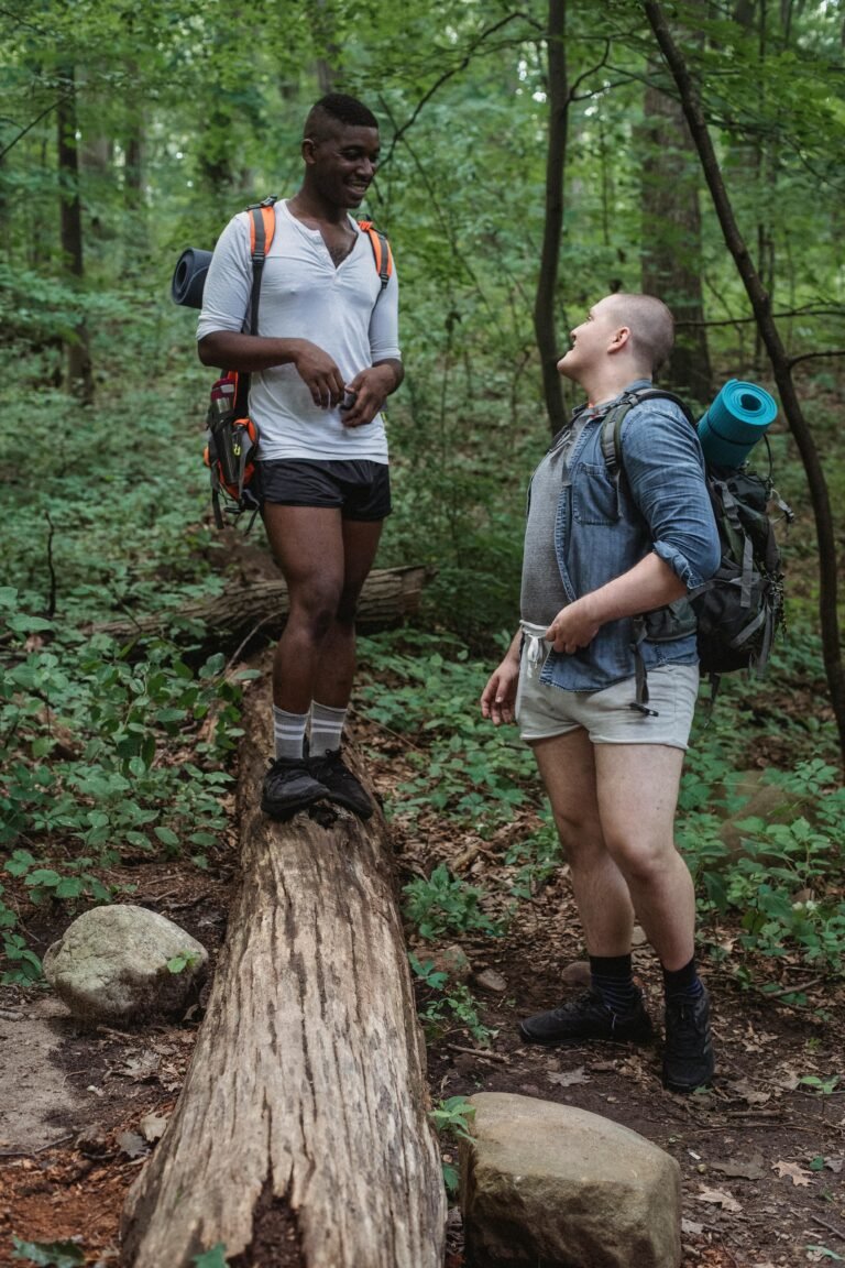 Two friends hiking and enjoying conversation in a green forest setting.